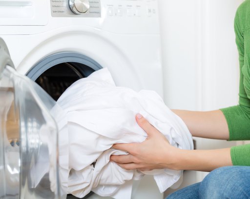 Young woman or housekeeper has a laundry day at home